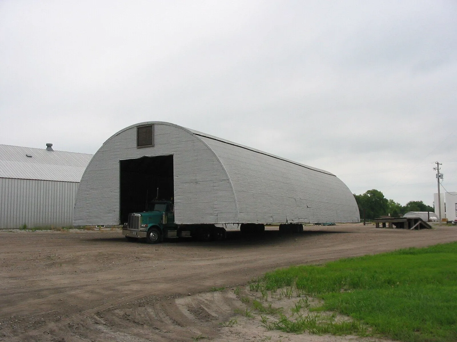 A long corrugated quonset building on a trailer