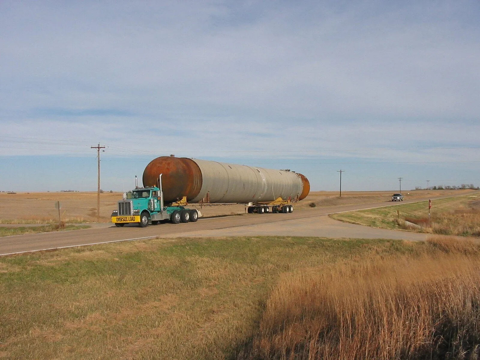 Long steel tank on a trailer on a prairie road