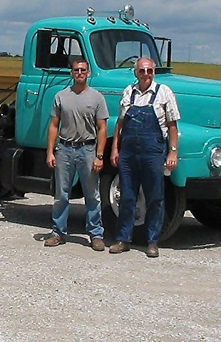 John and Gary Williams standing in front of a restored teal 1951 International truck